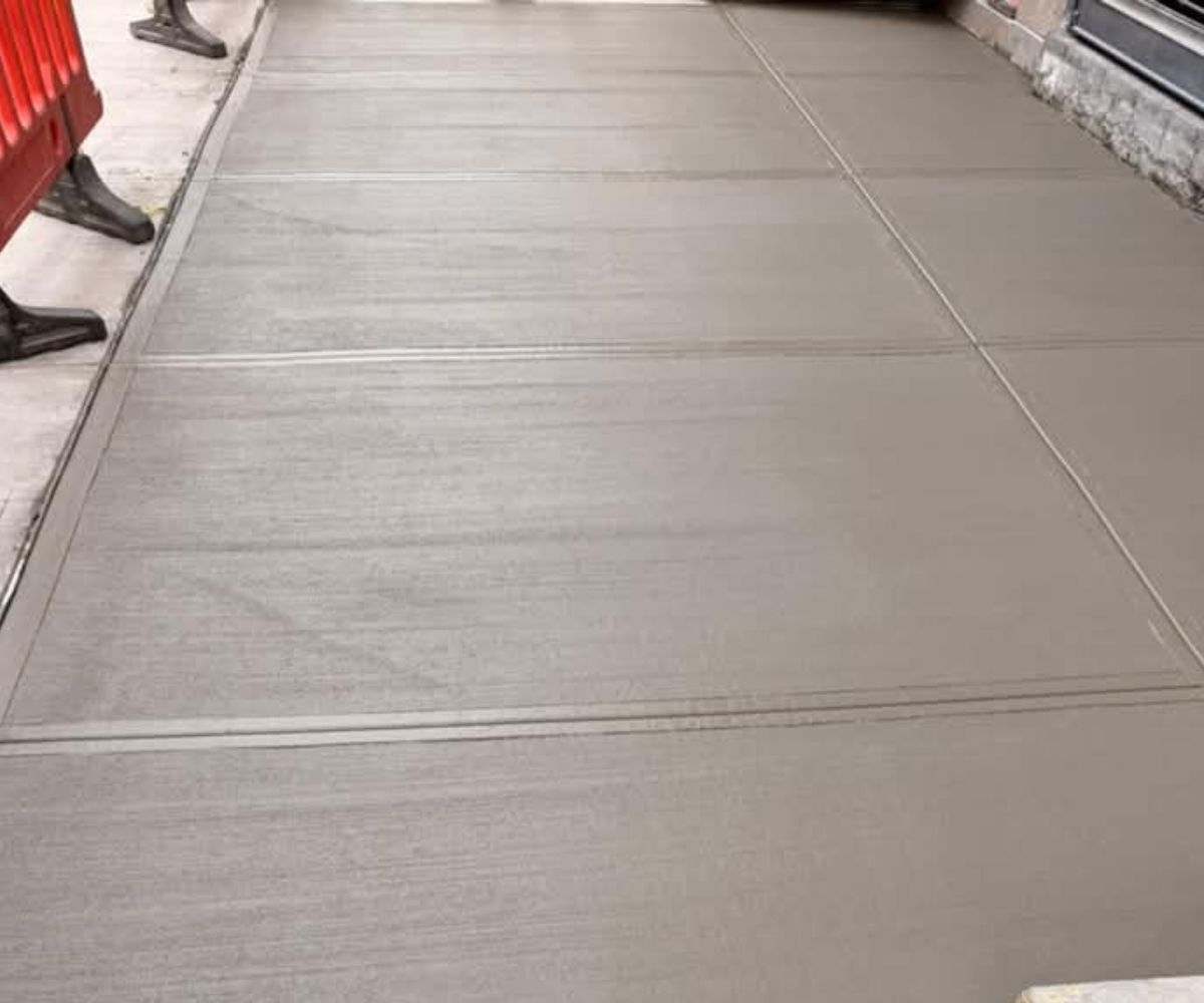 Freshly finished concrete sidewalk outside 208 Grand Street in SoHo, Manhattan, following the replacement of 14 damaged slabs.