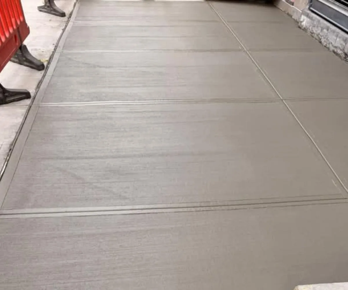 Freshly finished concrete sidewalk outside 208 Grand Street in SoHo, Manhattan, following the replacement of 14 damaged slabs.